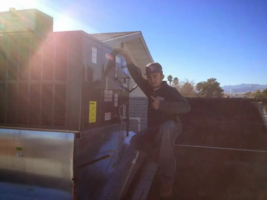 HVAC technician performing AC Tune-Up on a rooftop unit in Helena Valley Northwest